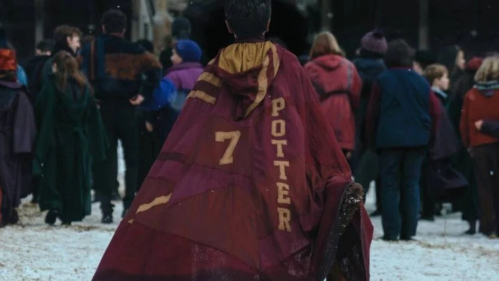 Harry Potter caminhando para o campo de Quadribol em Hogwarts na série da HBO